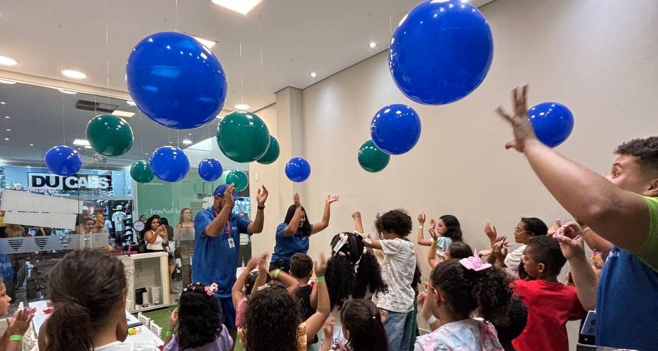Crianças e monitores da Cria Atividade em uma festa divertida com balões coloridos